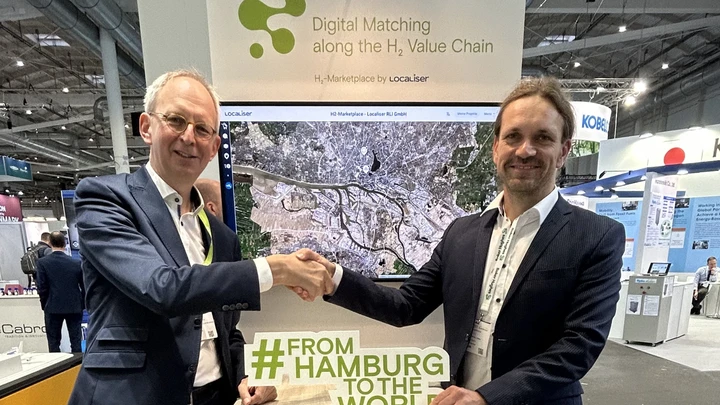 Jan Rispens and Oliver Arnhold shaking hands at the H₂ Marketplace stand