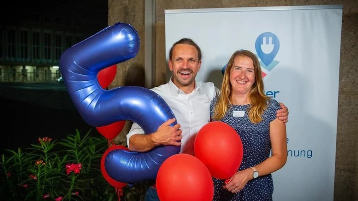 Two Localiser team members with a balloon in the shape of a 5
