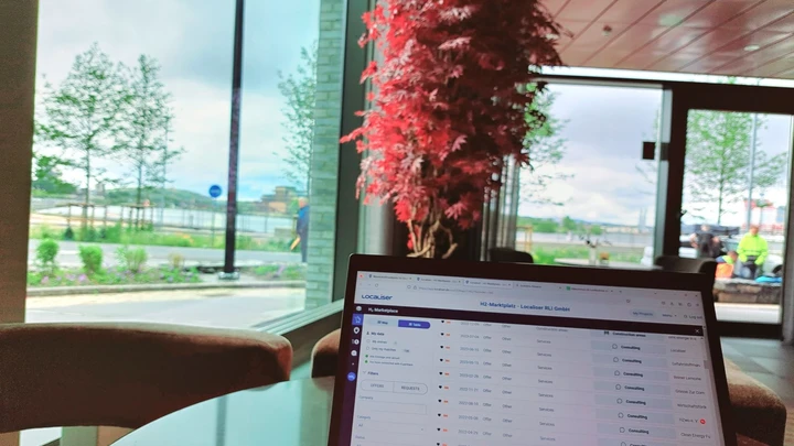 Laptop showing the hydrogen marketplace in a room overlooking the water in Gothenburg