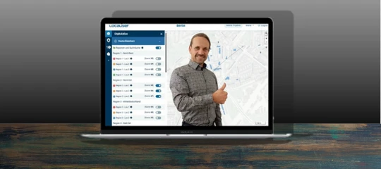 Laptop mit der Localiser-App und einem Mitarbeiter, der den Daumen hebt