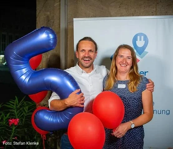 Two Localiser team members with a balloon in the shape of a 5